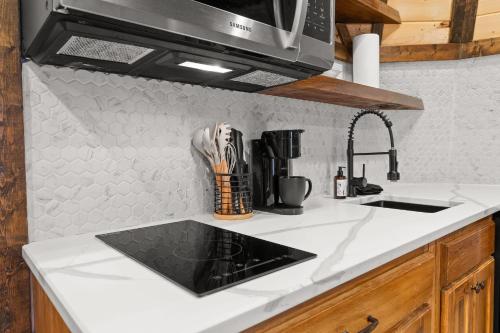 a kitchen counter with a sink and a microwave at TeePee at Paradise Point with a hot tub fire pit & grill in Bryant