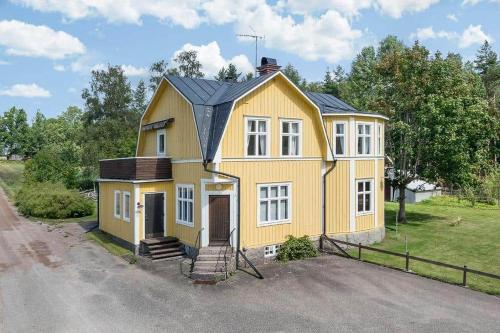 a yellow house with a black roof at JON440-Paulistrom-Haesslehult-6 in Hässlehult