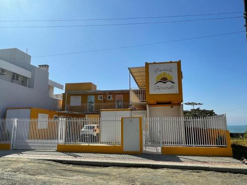 a building with a fence and a sign on it at Pousada Luz do Sol in Penha