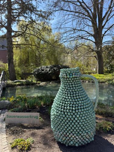 a large jug sitting on the ground in a garden at Altes Pfarrhaus Hotel und Restaurant in Bad Überkingen
