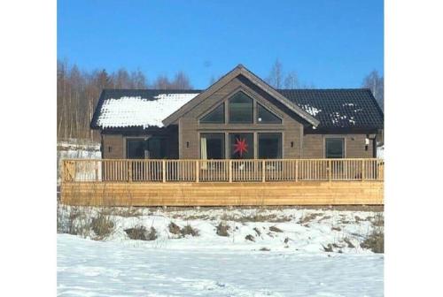 a log home with a deck in the snow at GAV792-Jaerbo-Skogsbrovaegen-22 in Botjärn