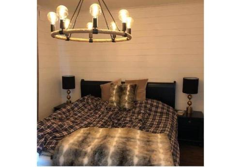 a bedroom with a bed and a chandelier at GAV792-Jaerbo-Skogsbrovaegen-22 in Botjärn