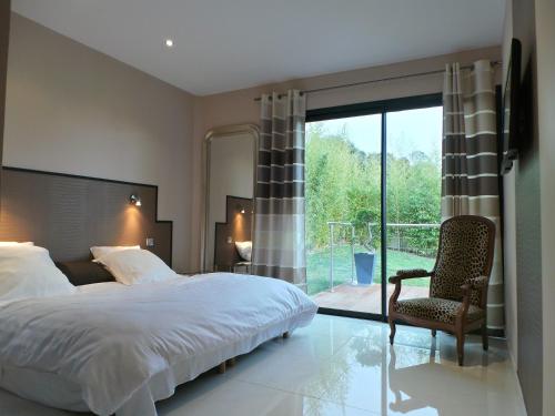une chambre avec un lit, une chaise et une fenêtre dans l'établissement Grande Villa 350 M2, piscine chauffée vue mer et collines, CAVALAIRE sur mer, 10 personnes, à Cavalaire-sur-Mer