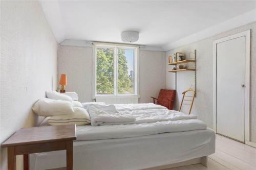 a white bedroom with a large bed with a window at KRO539-Haeradsbaeck-Torbjoernahult-4074 in Torbjörnahult