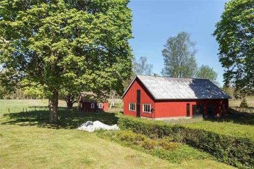 a red barn in a field with a tree at KRO539-Haeradsbaeck-Torbjoernahult-4074 in Torbjörnahult