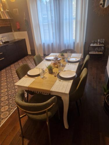 a wooden table with chairs and plates on it at Albert Rd Aparthotel in Colne