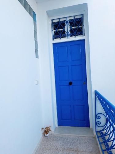 a blue door on the side of a white building at Dar Aziz VIP in Sousse