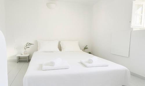 a white bedroom with a white bed with two white pillows at Sifnos Blue Horizon House Kastro Endless Blue in Apollonia