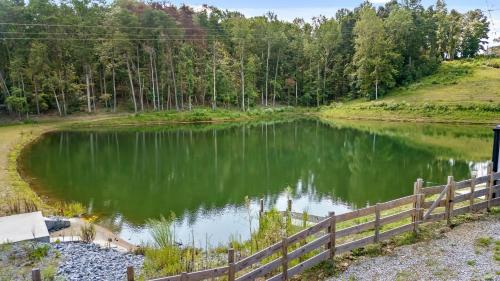 a small pond with a fence around it at Cloud 9 Cabin with an indoor pool hot tub & fire pit in Bryant