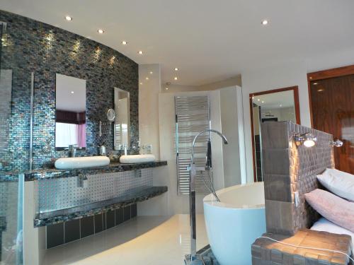 une salle de bains avec baignoire, deux lavabos et douche dans l'établissement Grande Villa 350 M2, piscine chauffée vue mer et collines, CAVALAIRE sur mer, 10 personnes, à Cavalaire-sur-Mer