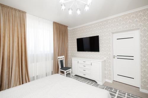 a bedroom with a bed and a tv on a wall at Aparthotel Royal Status in Chişinău