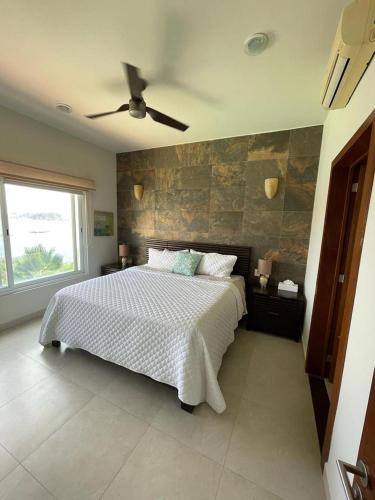 a bedroom with a bed and a ceiling fan at Oceanview Punta Arrocito Luxury Condo, Near Arrocito Beach in Santa Maria Huatulco