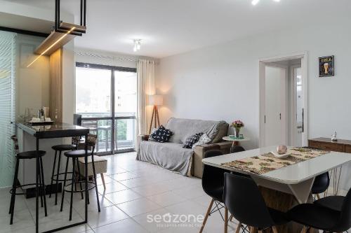 a living room with a couch and a table at Apto com varanda e churrasq 500m da praia RML605 in Imbituba