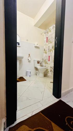 a white bathroom with a sink and a toilet at Cozy Apartment Near Rabat & Beach in Temara