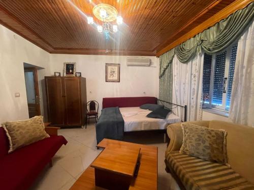una sala de estar con una cama y un sofá en Nafo Rooms, en Gjirokastra