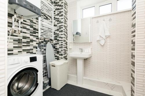 a bathroom with a washing machine and a sink at Aparthotel Royal Status in Chişinău
