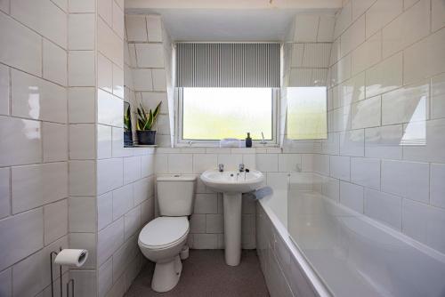 a bathroom with a toilet and a sink and a tub at Spacious apartment sleeps 6 - Uni, sports, trades in Nottingham