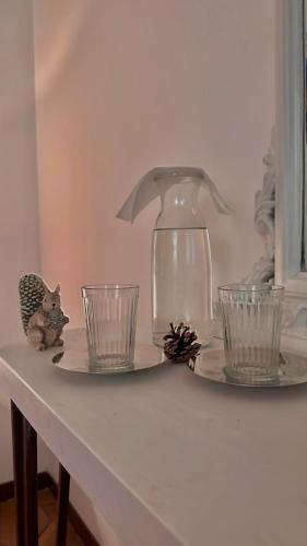 a table with two glasses and a lamp on it at Il Bosco Guest House Subiaco in Subiaco