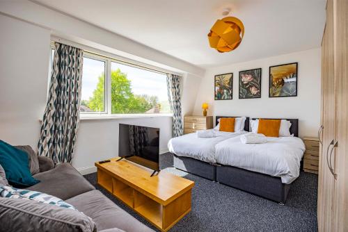 a living room with two beds and a couch at Spacious apartment sleeps 6 - Uni, sports, trades in Nottingham