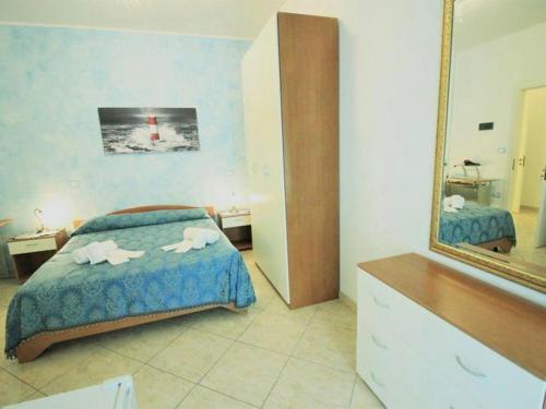 a bedroom with a bed and a mirror and a dresser at Hotel Costa - Perla in Salve