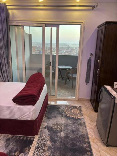 a bedroom with a bed and a balcony with a table at arwa pyramids view in Cairo