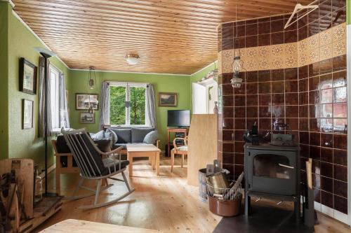 a living room with a wood stove and a couch at HAL657-Knaered-Bjoerkered-72 in Körsveka