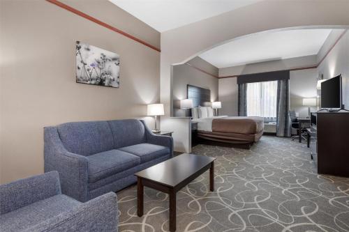 a hotel room with a couch and a bed at Best Western Limestone Inn and Suites in Mexia