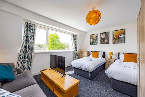 a living room with two beds and a couch at Spacious apartment sleeps 6 - Uni, sports, trades in Nottingham