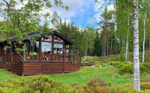 a large wooden house in the middle of a forest at KRO771-Russby-Rungebacken-Uddeboda-3 in Piggaboda