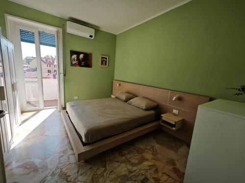 1 dormitorio con 1 cama en una pared verde en Casa Augusta, en Milán