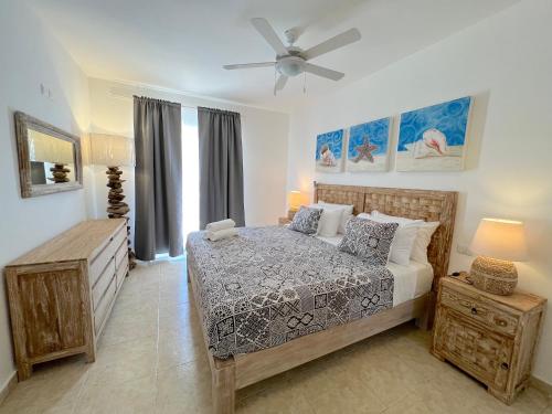 a bedroom with a bed and a ceiling fan at SANDY BAY VILLAS and SUITES playa LOS CORALES in Punta Cana