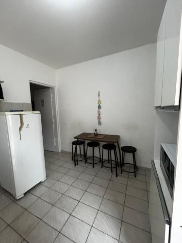 a kitchen with a table and chairs and a refrigerator at Apartamento Tati Ortega in Ilha Comprida