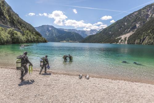two people standing on the shore of a lake at Villa Aigner in Achenkirch