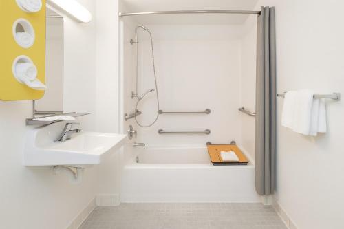 a white bathroom with a shower and a sink at Motel 6-Thousand Oaks, CA in Thousand Oaks