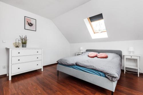a white bedroom with a bed and a dresser at Loft Apartment - Year-Round Lakefront Apartment in Kamień Only 30 Minutes from Gdańsk and Gdynia in Kamień