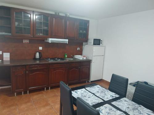 a kitchen with wooden cabinets and a table and a white refrigerator at Casa Santa Maria - apartamento A in Ermidas