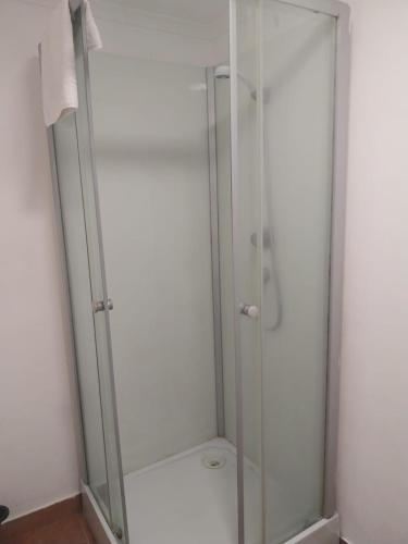 a shower with a glass door in a bathroom at Casa Santa Maria - apartamento A in Ermidas