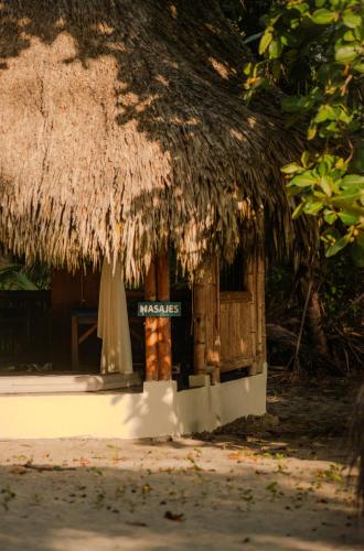 a hut with a straw roof with a sign on it at Hotel Playa Bonita Tayrona in Buritaca