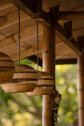 two wicker baskets hanging from a wooden roof at Hotel Playa Bonita Tayrona in Buritaca