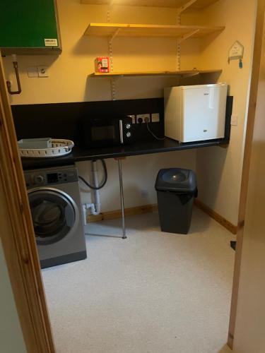 a small room with a microwave and a washing machine at 33 Liberator Drive, Kirkwall in Orkney