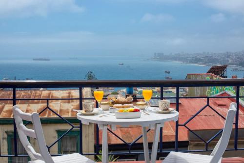 a table with food and drinks on a balcony at Hotel Casa Somerscales in Valparaíso