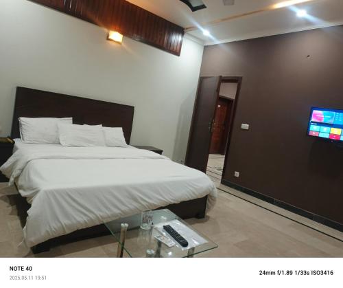 a hotel room with a bed and a tv at Destination Home in Islamabad