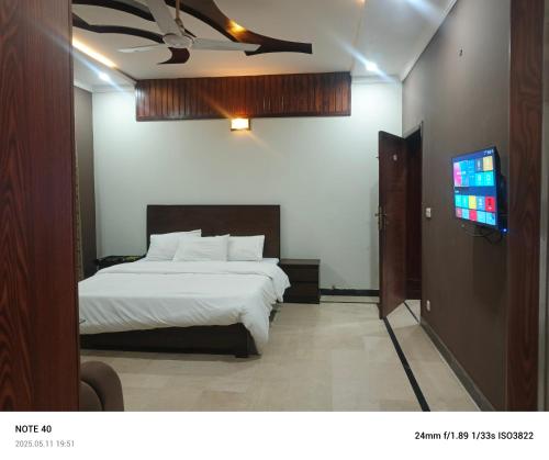 a bedroom with a bed and a flat screen tv at Destination Home in Islamabad