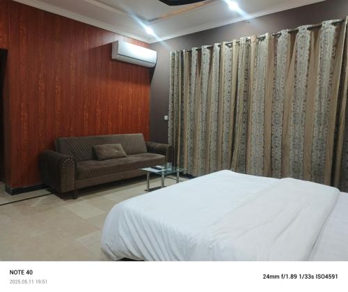 a hotel room with a bed and a couch at Destination Home in Islamabad