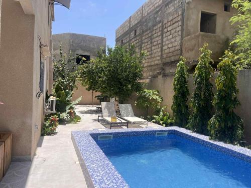 a swimming pool in the courtyard of a building at Maison de vacances in Mbour