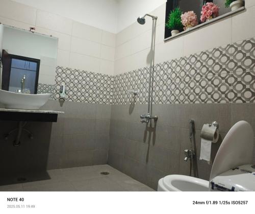 a bathroom with a sink and a shower and a toilet at Destination Home in Islamabad