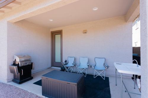 a patio with four chairs and a stove and a sink at Modern Desert Home-Great for families & groups, near golf, hiking, and city fun in Phoenix