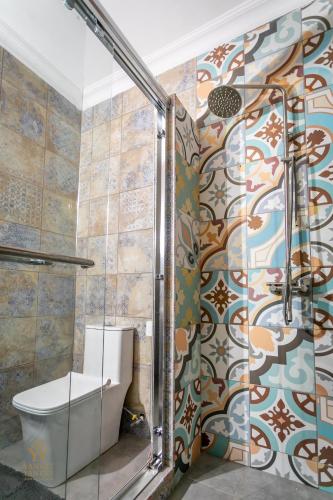 a bathroom with a shower and a toilet at Yankey Yankey Apartments-Kansaworado in Takoradi