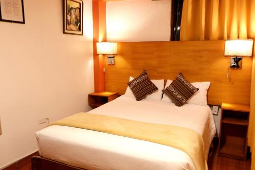 a bedroom with a large white bed with two pillows at Amakonkay Machupicchu in Machu Picchu