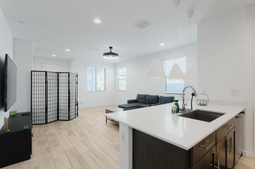 a kitchen and living room with a sink and a refrigerator at Modern Desert Home-Great for families & groups, near golf, hiking, and city fun in Phoenix